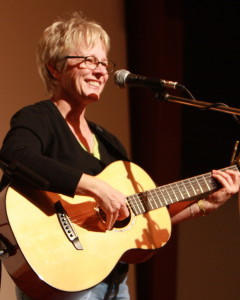 photo of Tracy Newman standing on stage with acoustic guitar at Folktacular 2008